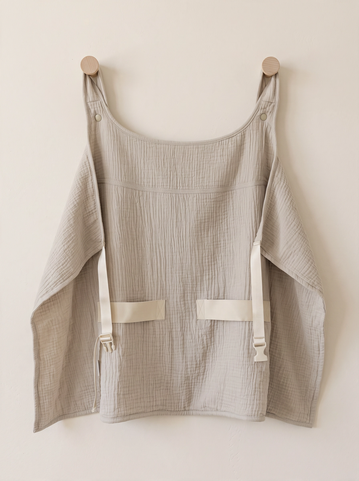 The backside of sunshell sun cover in Sand, a light beige cotton cover for babywearing 